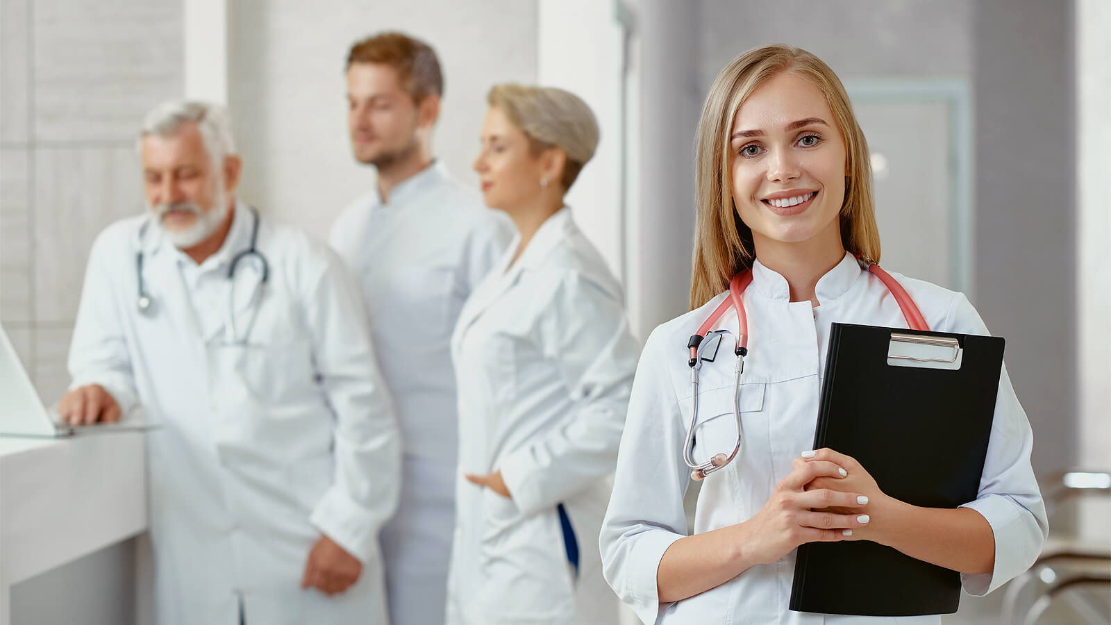 Lady doctor smiling and doctors working in the background